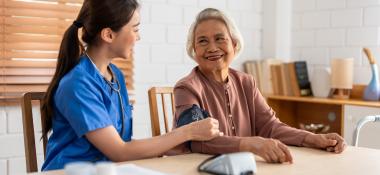 Nurse takes an elderly woman's blood pressure